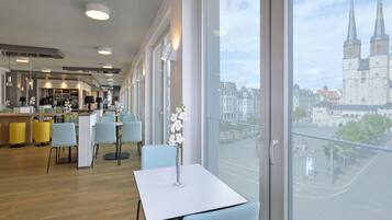 A modern hotel room with large windows offering a view of a historic building.