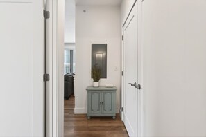 A hallway with a light blue cabinet, a mirror, and a door.