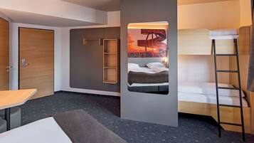 Habitació d'hotel moderna amb una llitera, un escriptori i un armari.