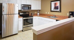 Enjoy cooking in this well-equipped kitchen with a refrigerator, microwave, oven, sink, and coffee maker.