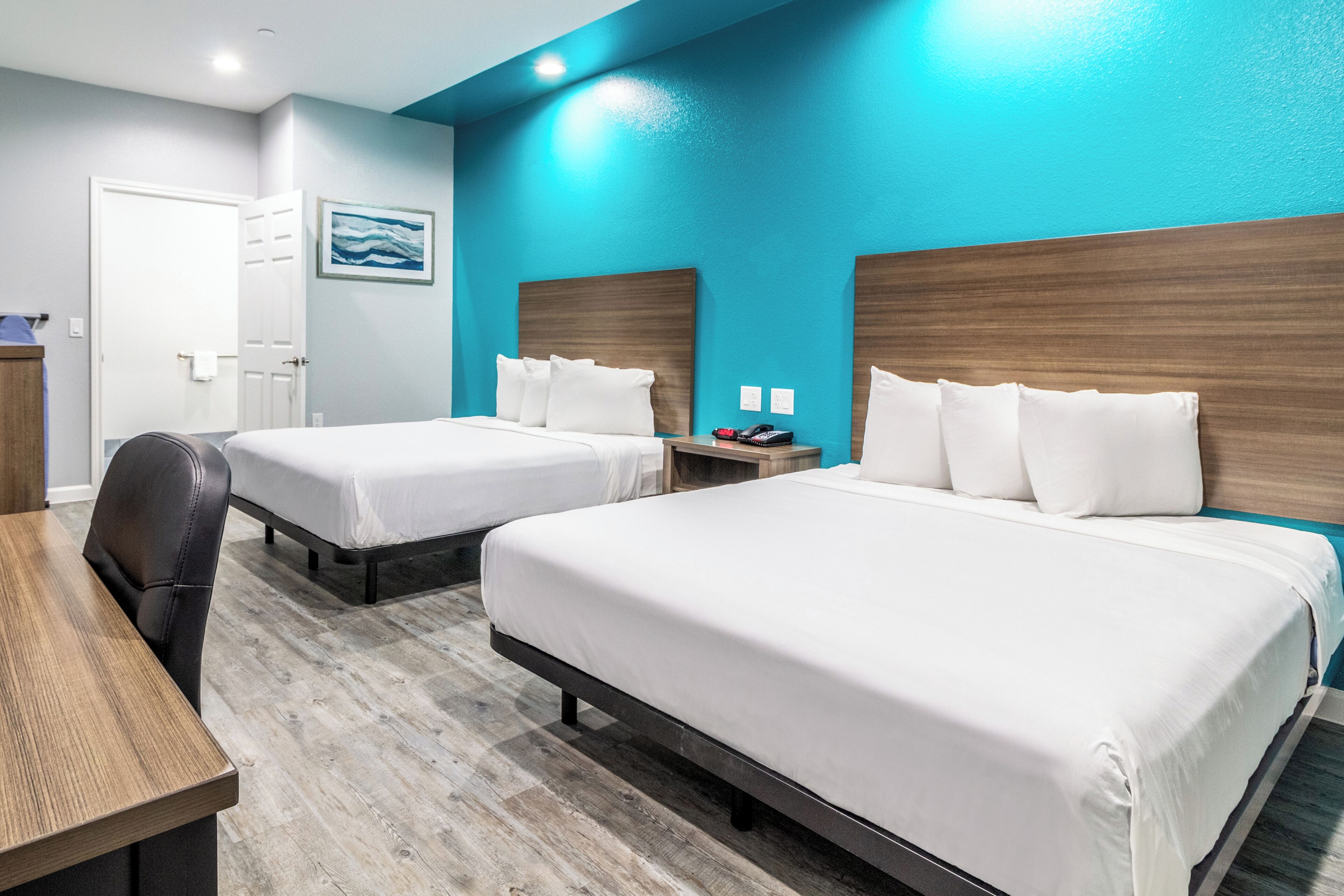 Habitació d'hotel amb dos llits, una taula i una cadira.