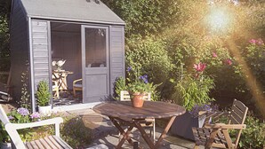 A wooden deck with a table and chairs, surrounded by potted plants and flowers. - Lower Canterbury House (Gattonside, near Melrose)