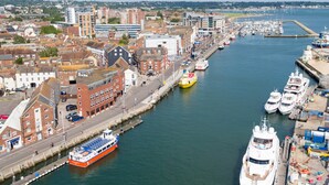 A harbor with boats, a large cruise ship, and buildings along the waterfront. - Sunnyside - Apartment Moments from Poole Quay (Poole)