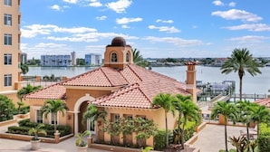 Un hotel con tetto in tegole rosse, una struttura a cupola e vista su un corpo d'acqua e altri edifici.