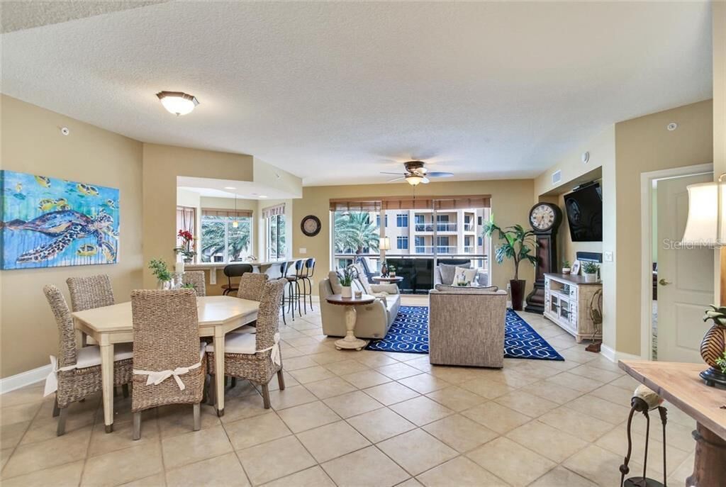 A spacious living room with a dining area, a fireplace, and a view of the outside.
