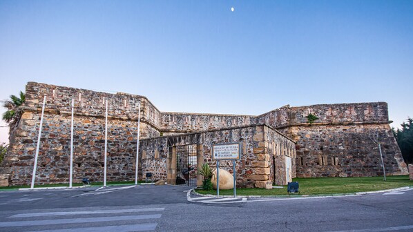 Um edifício histórico de pedra com uma placa indicando uma delegação cultural.