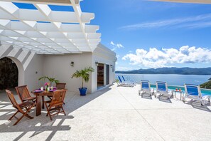 Relax in a serene oceanfront setting with a clear view of distant mountains.