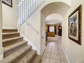 Staircase leads to a cozy upper level with a door to another room and a framed picture on the wall.