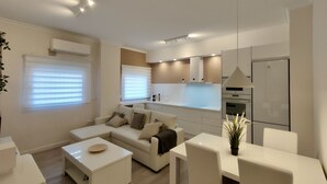 A modern living room with a sofa, coffee table, and dining area. - NON STRESS: Charming apartment (València)