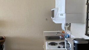 A compact kitchen with a microwave, stove, and coffee maker. - Cute Studio!  Remodeled!  Direct Ocean Front! Pirates Cove 6th Floor (Daytona Beach)