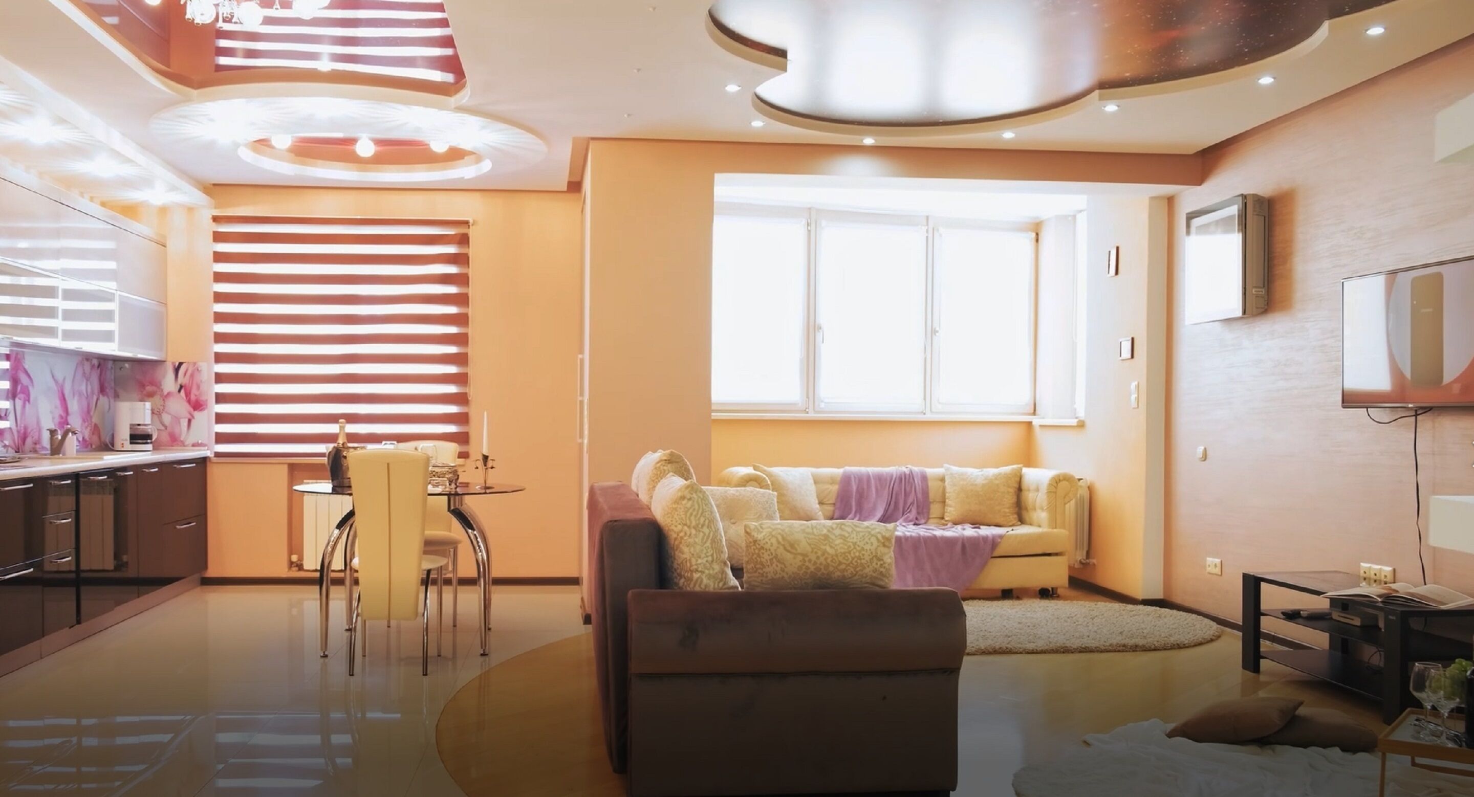 Una sala moderna con sofá, mesa de comedor y zona de cocina.