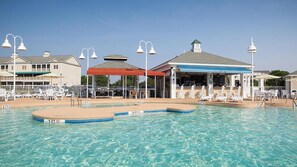 A swimming pool with a 3 FT depth marker, lounge chairs, and a covered pavilion with a blue awning. - Spacious condo near downtown Myrtle Beach, SC (Myrtle Beach)