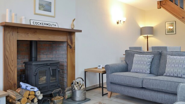 A cozy living room with a fireplace, a sofa, and a lamp.