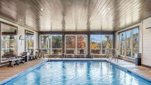 An indoor swimming pool with wooden ceiling, large windows, and outdoor views. - Grand LeConte Lodge | 21BR Luxury Estate w/ Pool, Theater, Arcade, Sleeps 96 (Pigeon Forge)