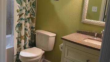 Een bad/douchecombinatie, handdoeken, zeep, shampoo