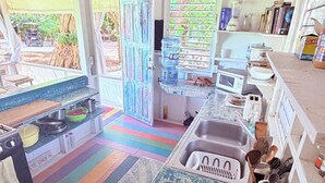 A kitchen with a colorful striped floor, a water dispenser, a sink, and a microwave.