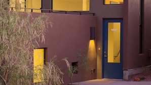 A modern two-story building with a blue door and large windows.