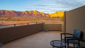 A balcony with a view of a desert landscape and mountains.