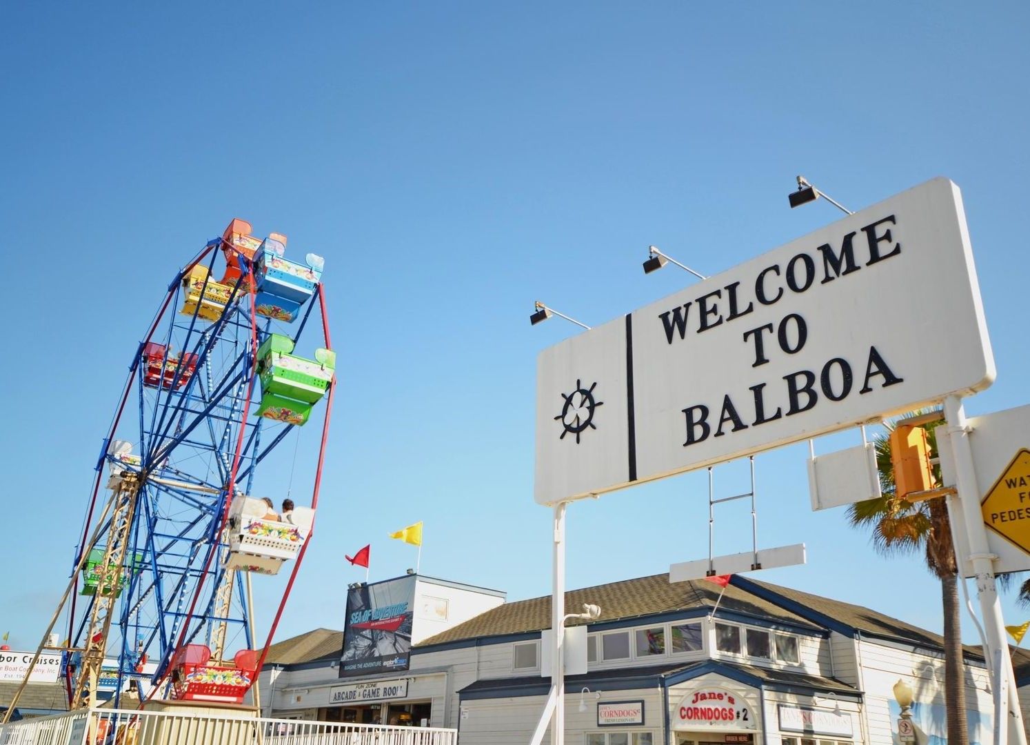 Een reuzenrad en een bord met de tekst 'WELKOM IN BALBOA'.