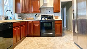 A modern kitchen with wooden cabinets, a stainless steel refrigerator, and a built-in oven. - Quiet home in the Kernersville near Winston Salem, Greensboro, High Point (Kernersville)
