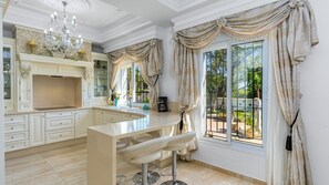 Enjoy cooking in this well-equipped kitchen with a central island and large window offering a view of the outdoors.