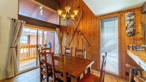 A wooden dining area with a chandelier, wooden chairs, and a table. - 1+Loft on Ski Back Trail at Canyon Lodge w/ Garage! (Mammoth Lakes)