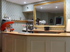 A bar area with a coffee machine, a mirror, and a Bacardi bottle.