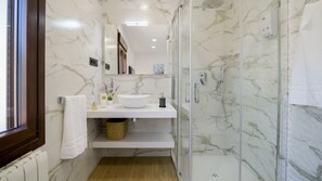 Ein modernes Badezimmer mit Waschbecken, Spiegel und Dusche.