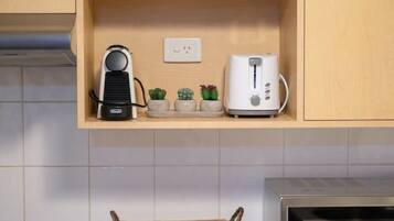A kitchen with wooden cabinets, a microwave, a toaster, and a basket on the counter.