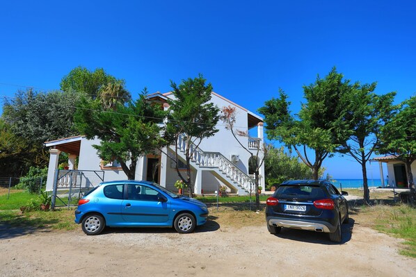 A coastal property with a two-story building, a staircase, and a view of the sea. - Beach Villa Vaso Ena: Beachfront, stunning views (Acharavi)