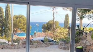 Ein Zimmer mit Meerblick, einer Steinwand und einem Sessel.
