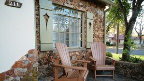 Two wooden Adirondack chairs outside a stone building with a window and shutters. - Emmie's | Great Location (Fredericksburg)