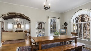 A spacious living room with a wooden dining table, a sofa, and a chandelier. - Emmie's | Great Location (Fredericksburg)