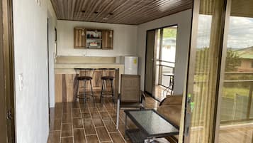 Una cocina moderna con armarios de madera, horno empotrado y una zona de bar con taburetes.