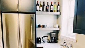 Uma cozinha moderna com geladeira de aço inoxidável, cafeteira e pia.