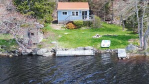 A house with a dock extending into a body of water, surrounded by trees and a grassy area. - Private Lakefront Escape – Swim, Sip Wine & Stargaze – 25 Mins to Halifax (Brookside)