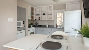 A modern kitchen with white cabinetry, a central island, and a built-in oven. - Private Lakefront Escape – Swim, Sip Wine & Stargaze – 25 Mins to Halifax (Brookside)