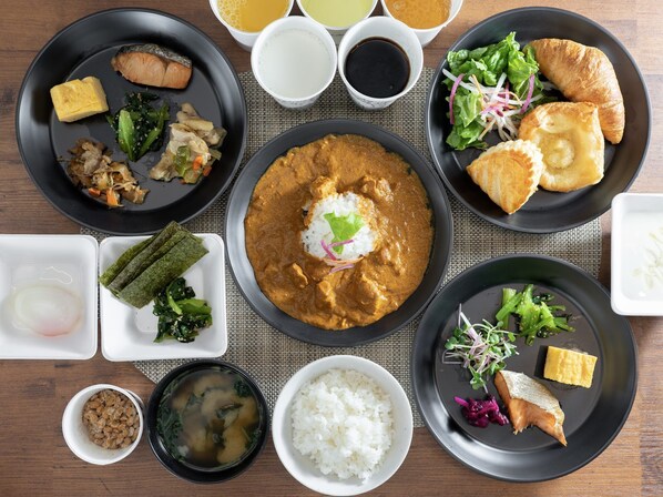 Une variété de plats, notamment du poisson, du riz et des légumes, présentés sur une table en bois.