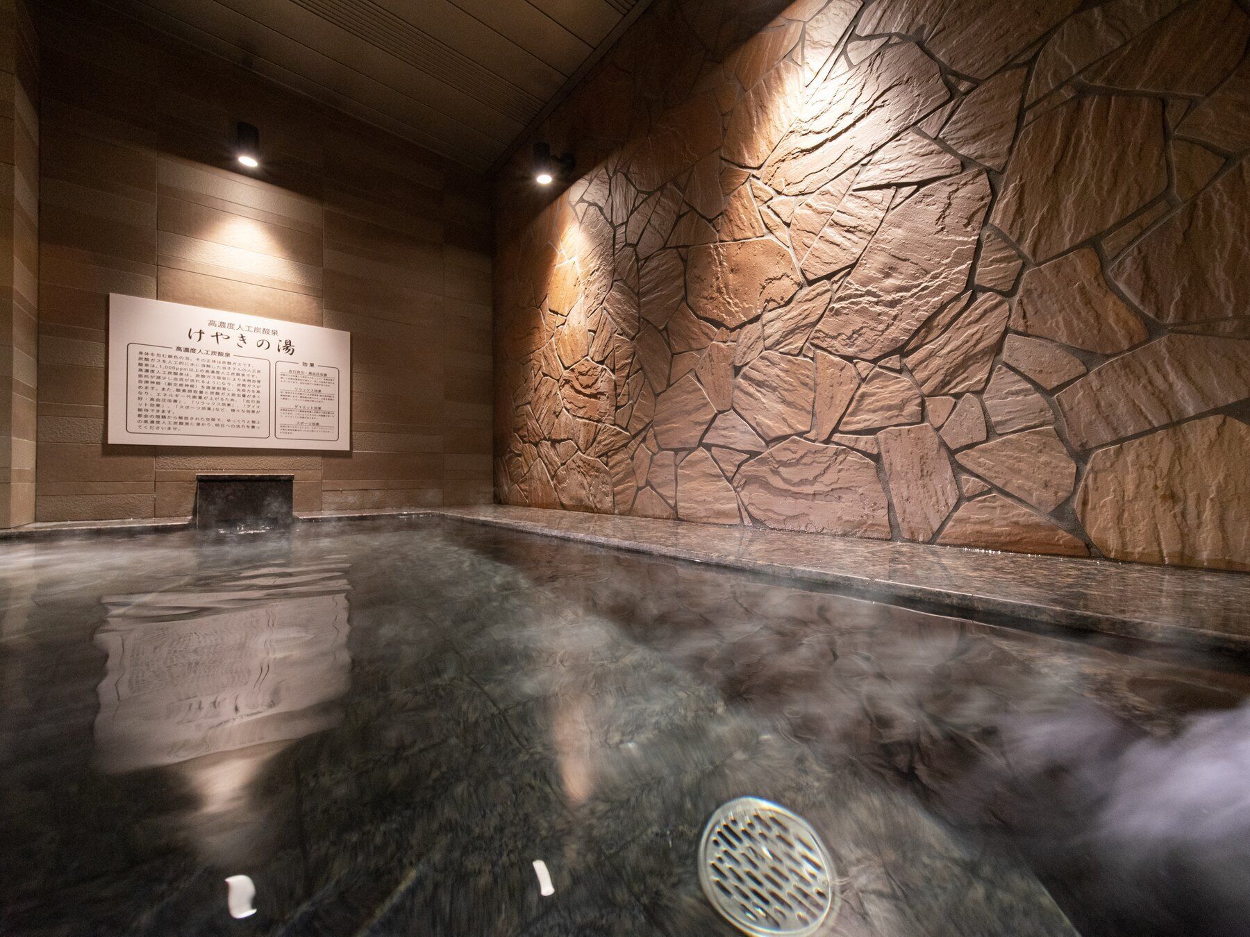 A spa area with a stone wall and a signboard.