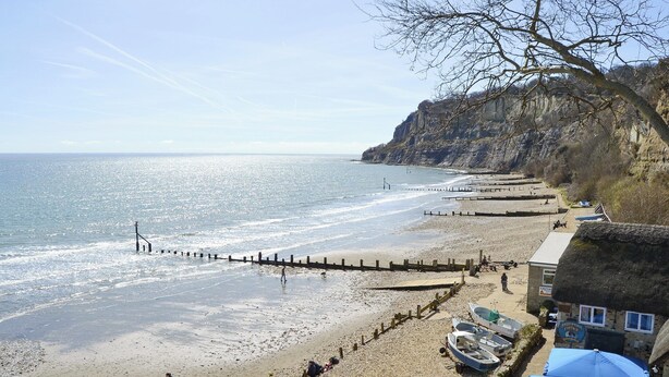 A coastal beach with a wooden jetty, boats, and a building with a thatched roof. - 3 bedroom accommodation in Ryde (Ryde)