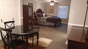 Cozy retreat with a large bed, dresser, and nightstand, perfect for relaxing and dining.