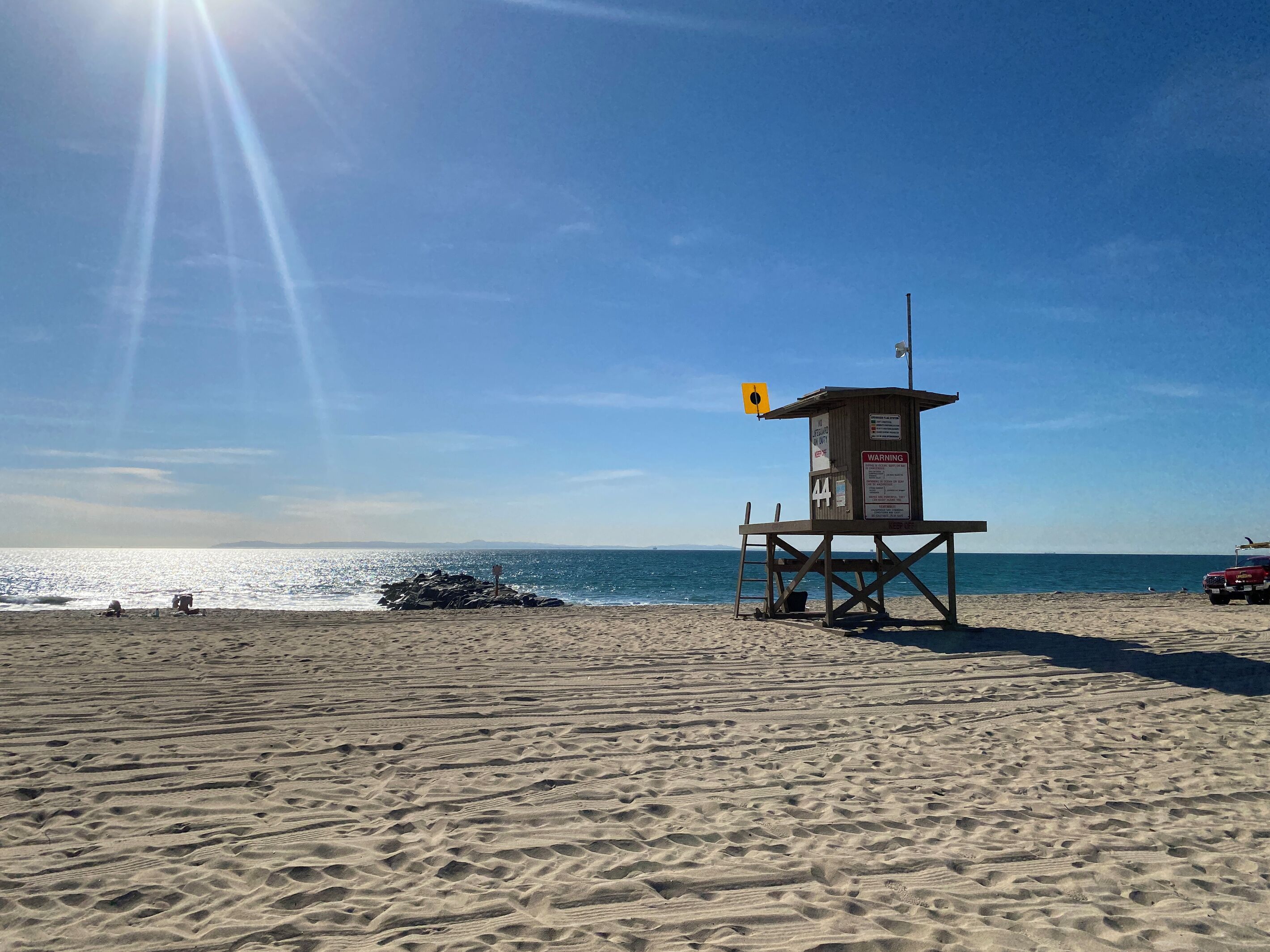 A lifeguard tower on a beach with clear skies and calm sea.