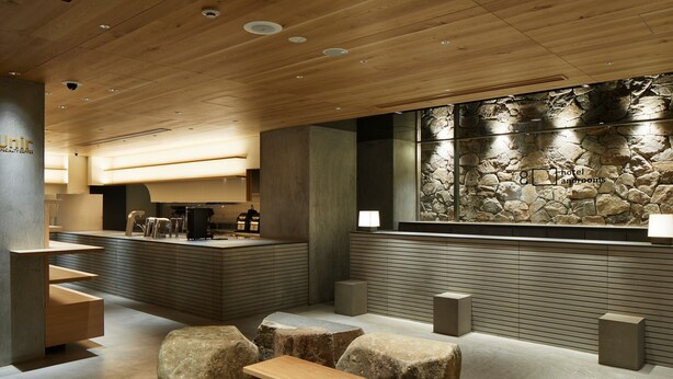 Ein modernes Interieur mit einer Steinwand, Holzmöbeln und einer Rezeption.