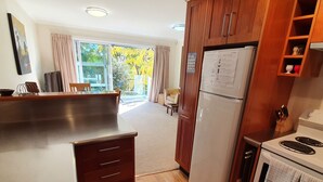 A modern kitchen with wooden cabinets, a built-in oven, and a refrigerator.