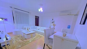 Uma sala de estar moderna com sofá, mesa de centro e mesa de jantar.
