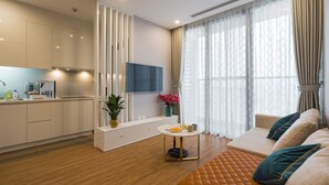 Een moderne woonkamer met een bank, een tafeltje en een keuken op de achtergrond.