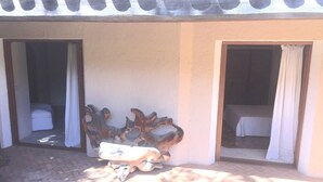 A room with a bed, a small table, and a decorative metal piece. There are two doors leading to other rooms. - Sea Front "House in the House" - Porto Cervo Costa Smeralda (Porto Cervo)