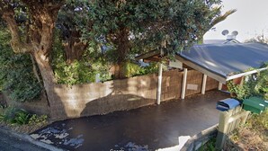A residential property with a large tree, a covered porch, and a metal roof. - Kimberley Three - Nelson Waterfront Apartment - Free Cancellation Available Here (Nelson)