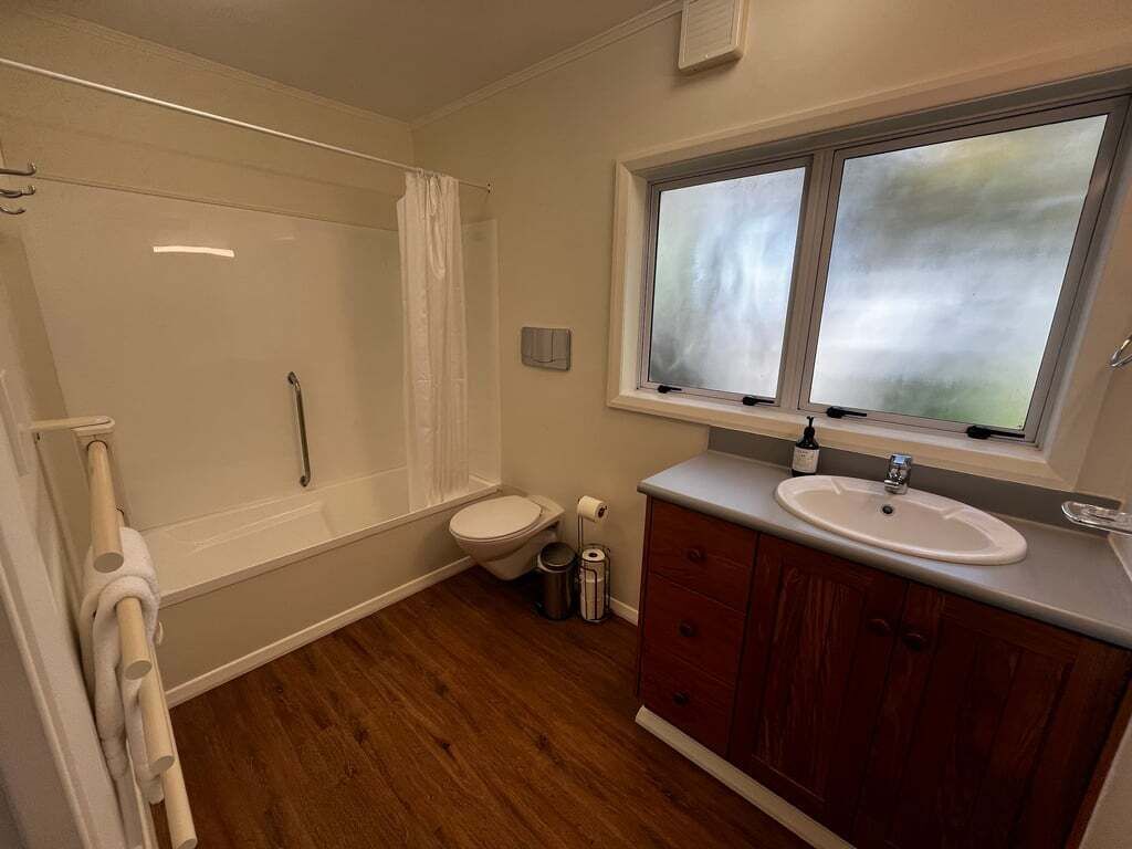 A bathroom with a shower, toilet, and sink.
