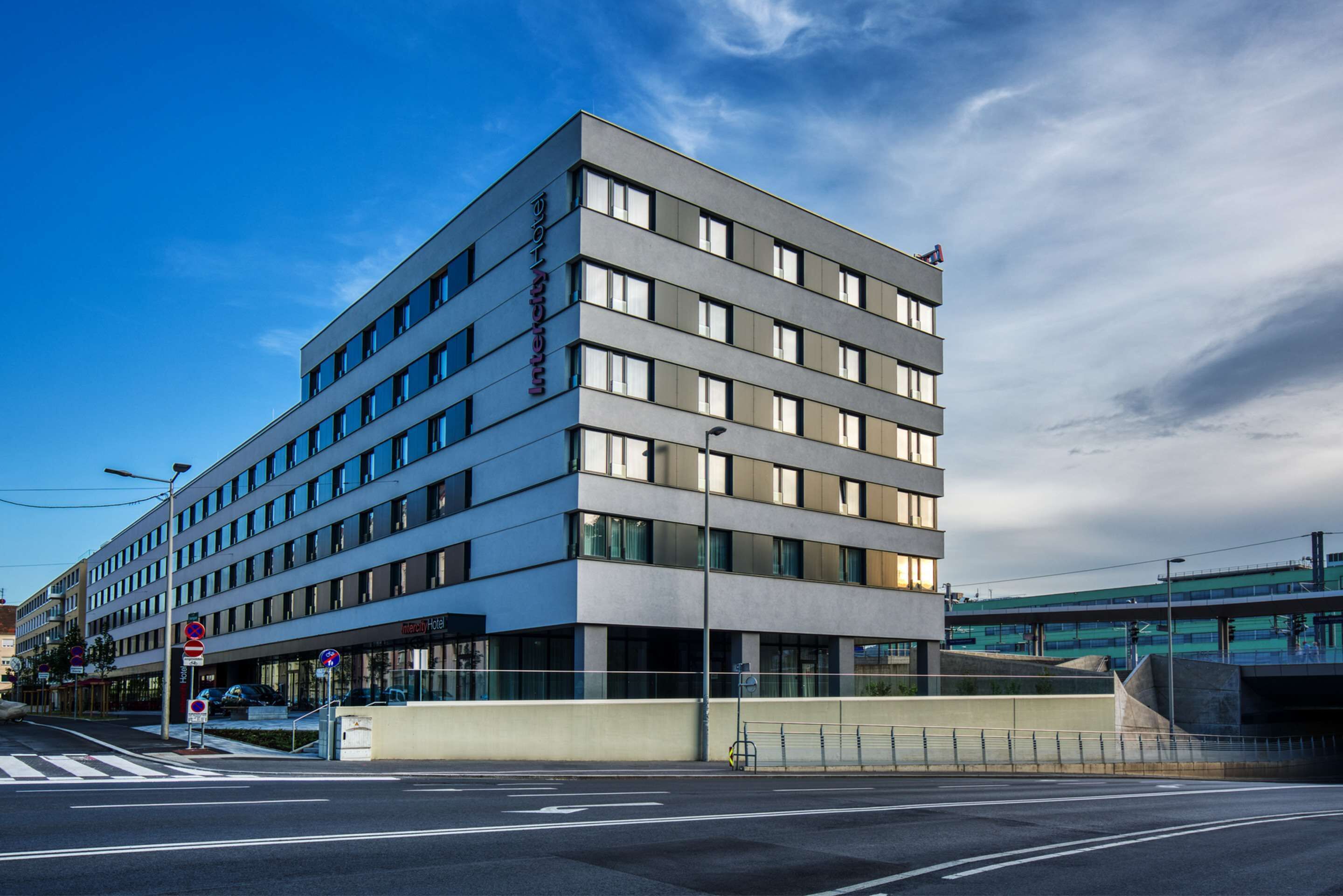 A modern hotel with multiple floors, large windows, and a flat roof.